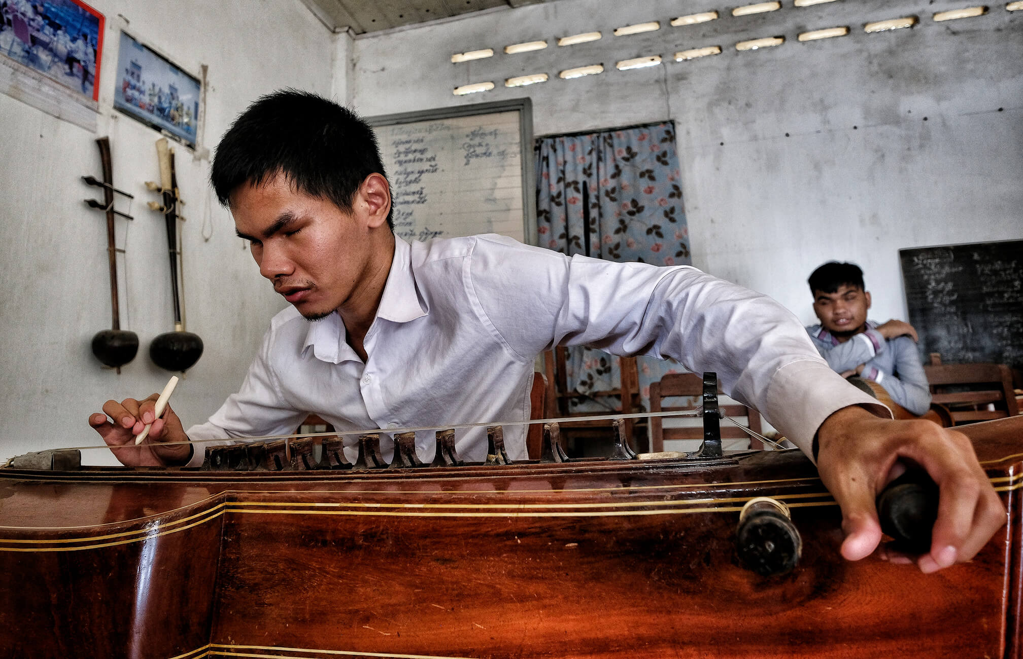 Person spielt auf einem traditionellem Instrument, der Takhe