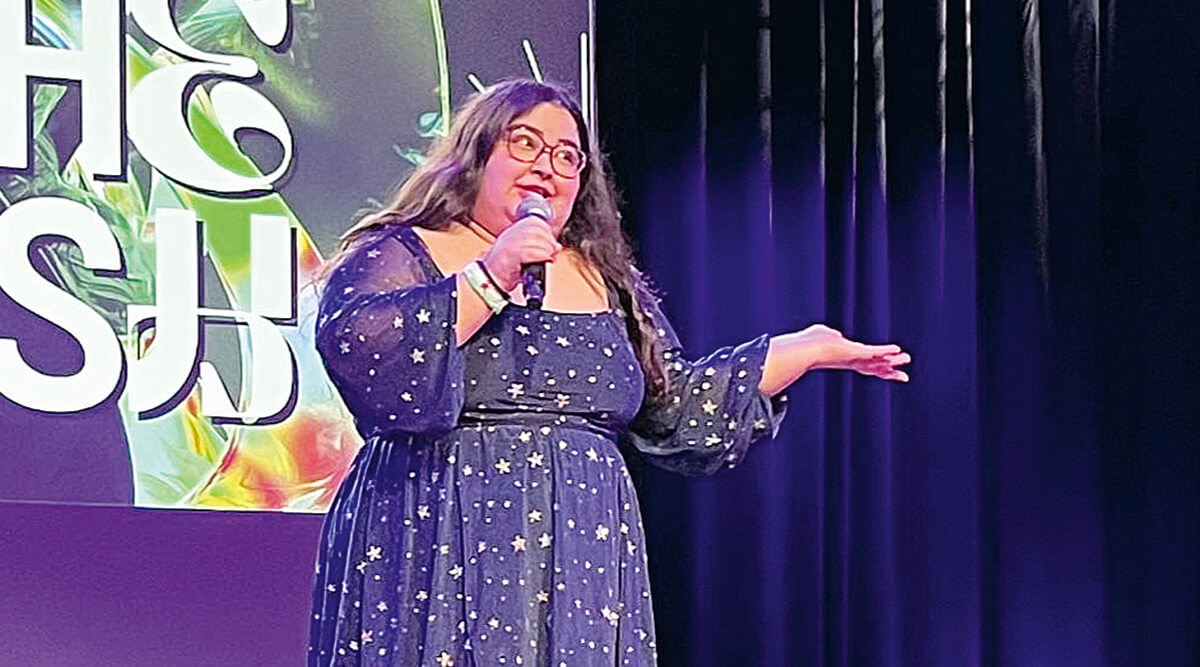 Comedian Flona auf der Bühne: Eine junge Frau mit Brille und langen Haaren spricht in ein Mikrofon.