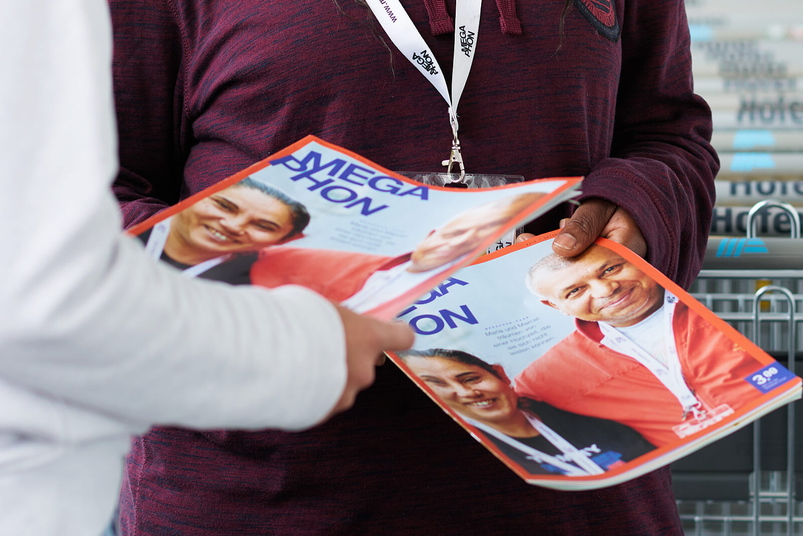 Zwei Personen halten jeweils ein Magazin mit dem Titel 'MEGAPHON' in den Händen.