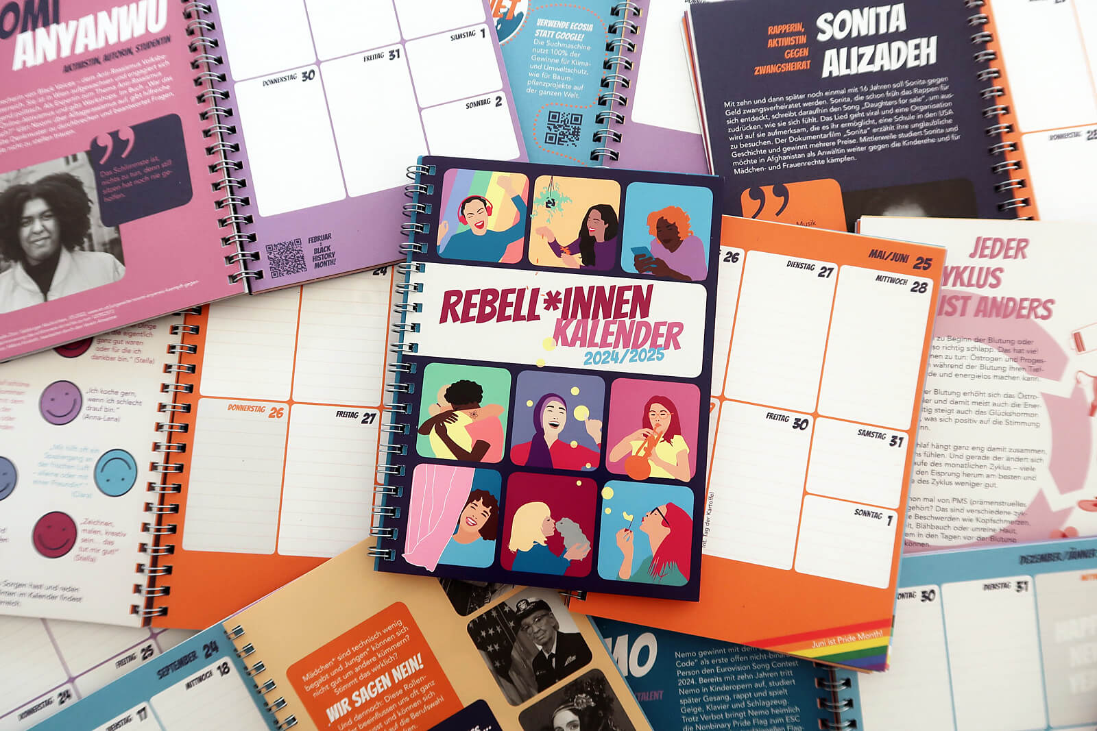 Mehrere Kalender mit feministischen Sprüchen und Illustrationen.