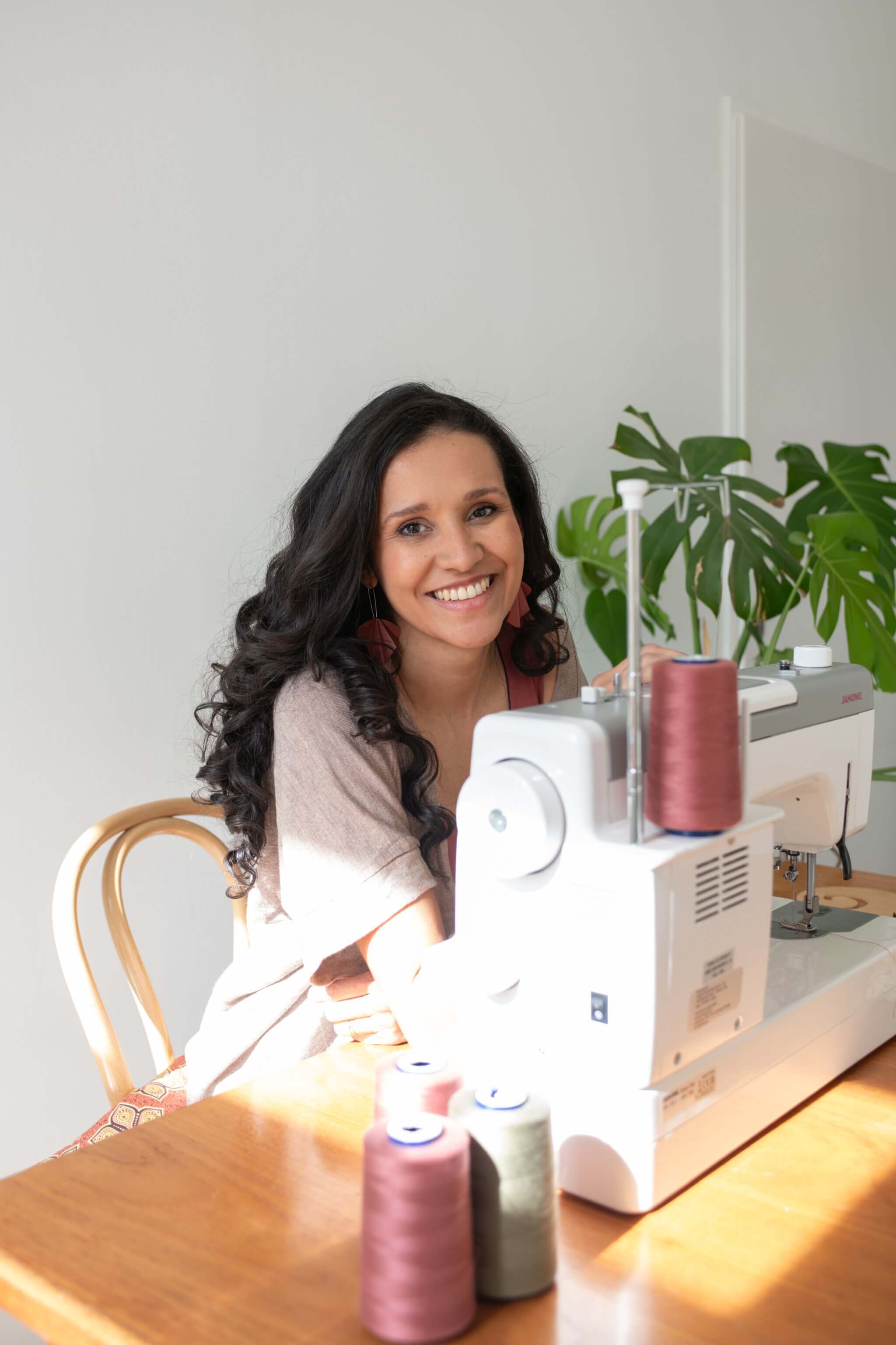 Flavia Soares sitzend an ihrer Nähmaschine