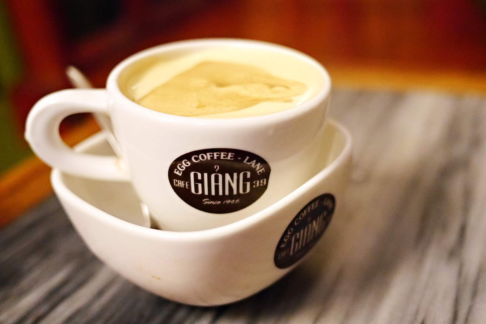 Eine Tasse cremiger Egg Coffee steht auf einer zweiten Tasse.