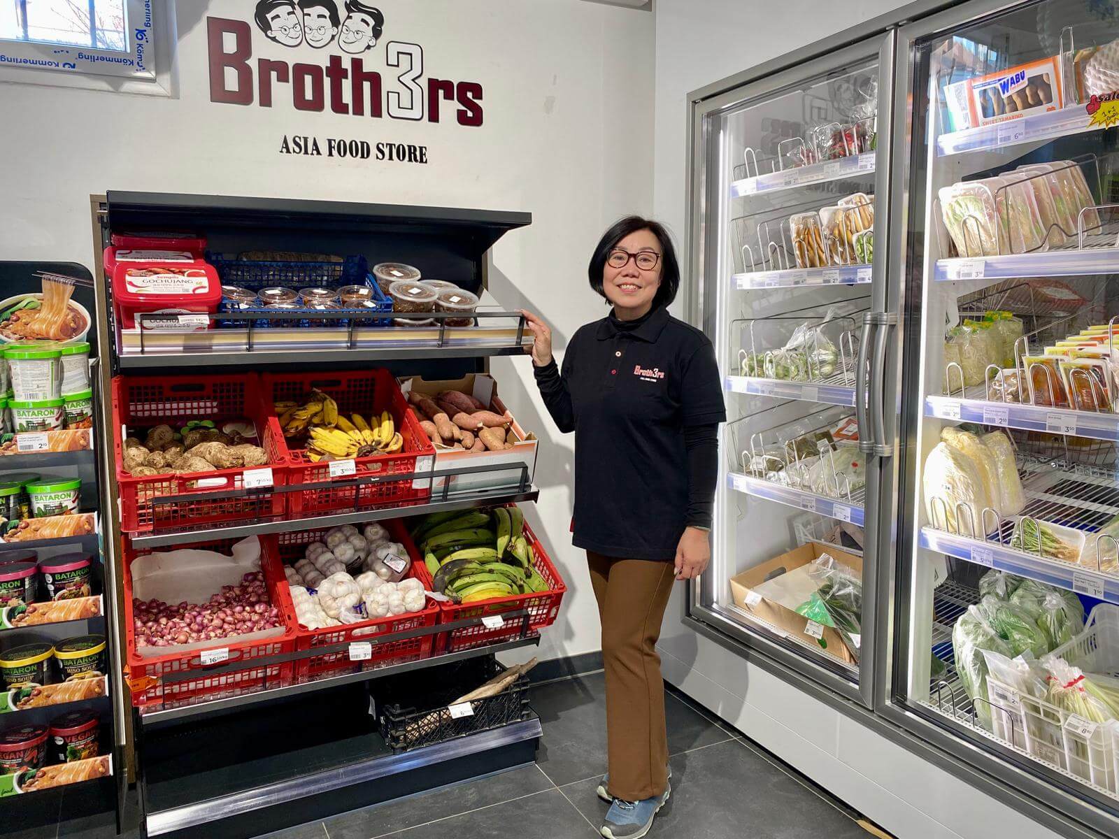 Thi-Yen Ly, Gründerin und Mutter der drei Brüder im renovierten Geschäft in Ottakring in Wien vor einem Regalen mit asiatischem Obst und Gemüse