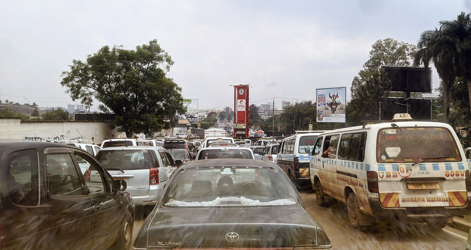 Dichter Stadtverkehr mit Autos, Taxis und Minibussen auf einer überfüllten Straße in Kampala, Uganda.