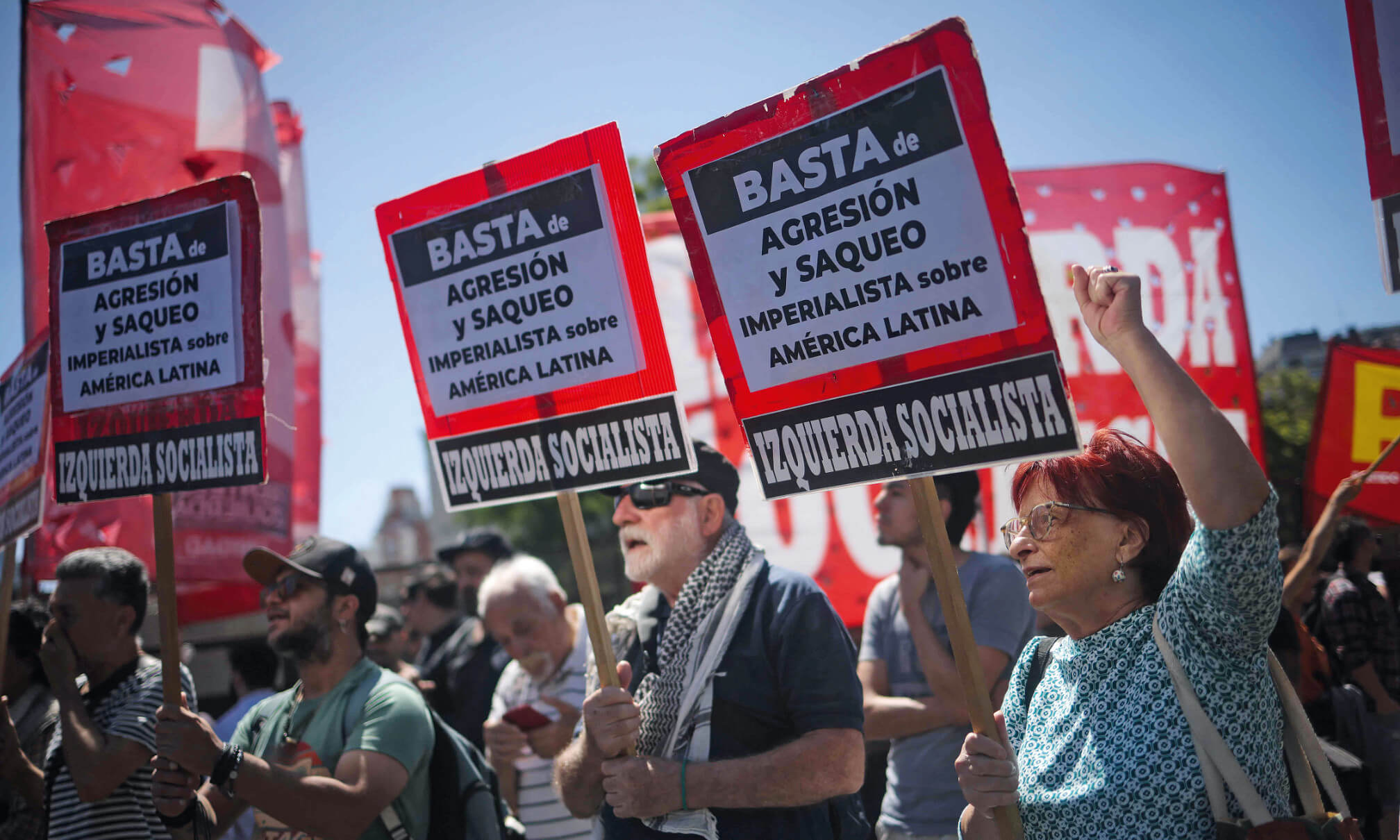 Demonstrierende halten bei einer Protestkundgebung rot-schwarze Schilder der „Izquierda Socialista